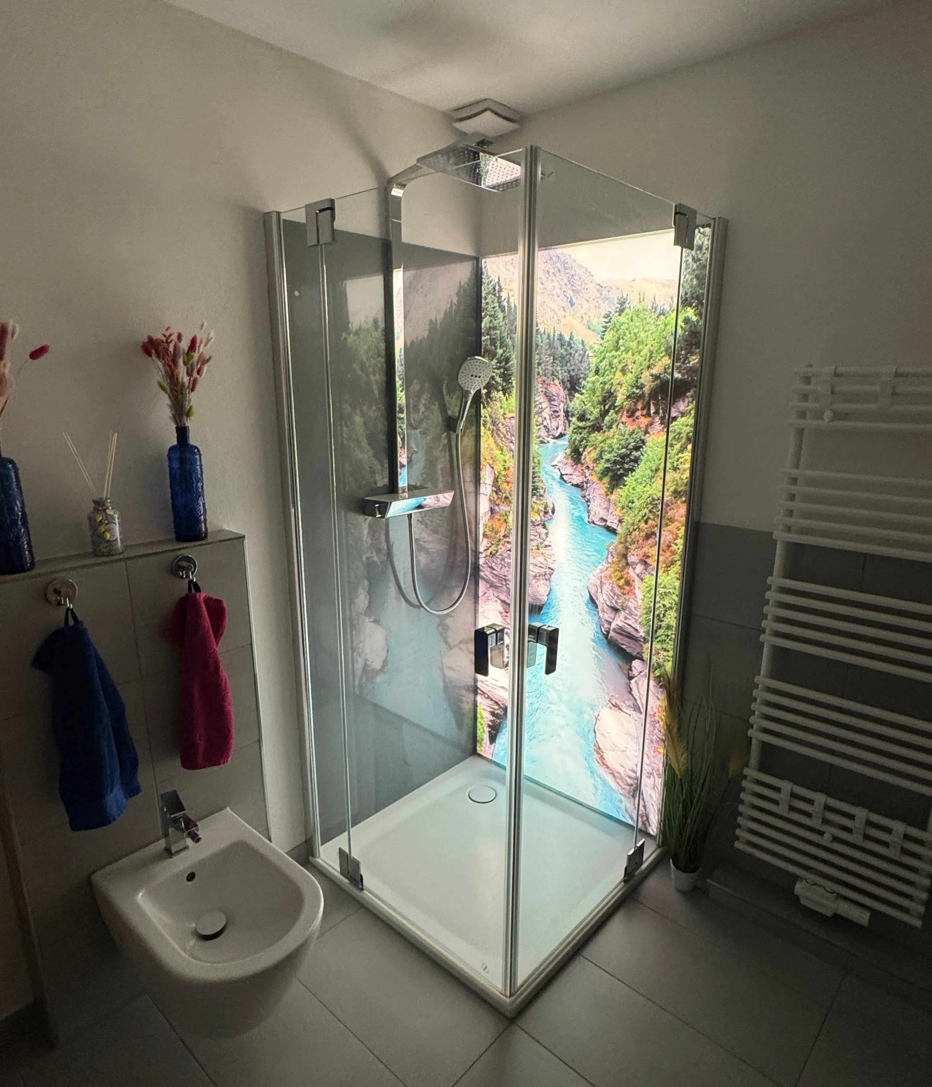 Moderne Eckdusche mit Glas und dekorativer Naturbild-Rückwand.