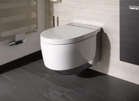Ein wandmontiertes Geberit AquaClean Mera Comfort Dusch-WC, dass sich perfekt in die moderne Badezimmergestaltung einfügt.