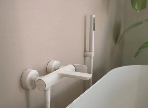 Die Frattini FLÒ Wandarmatur in matter Weißoptik ist elegant neben einer freistehenden Badewanne montiert.