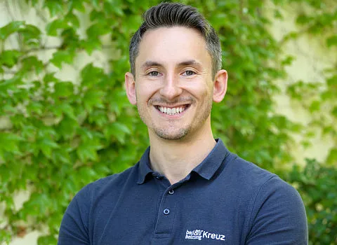 Portrait des Geschäftsführers Florian Goerke vor einer begrünten Wand.