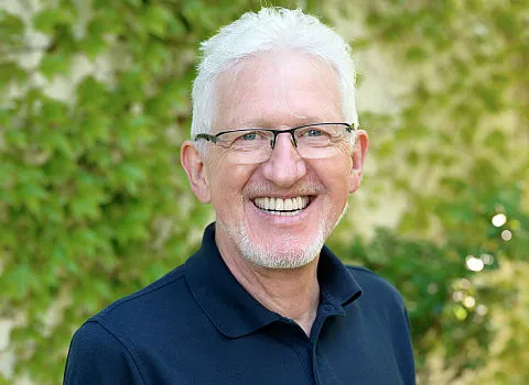 Potrait des Energieexperten Joachim Kreuz vor begrünter Wand.