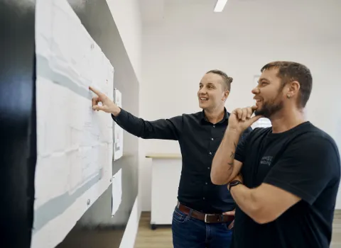 Projektleiter und Anlagenmechaniker im SHK-Handwerk besprechen die Planzeichnung eines Sanierungsprojektes.