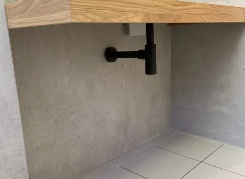 Ein Waschtisch in einem Gästebad in Holz-Optikholz