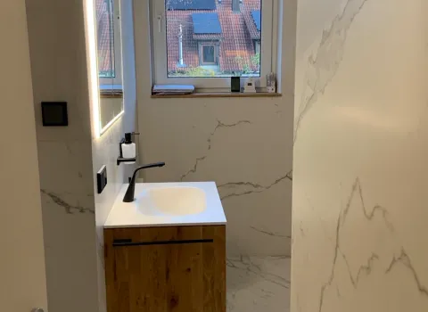 Kleines modernes Badezimmer mit Waschtisch, LED-Spiegel und Fenster.