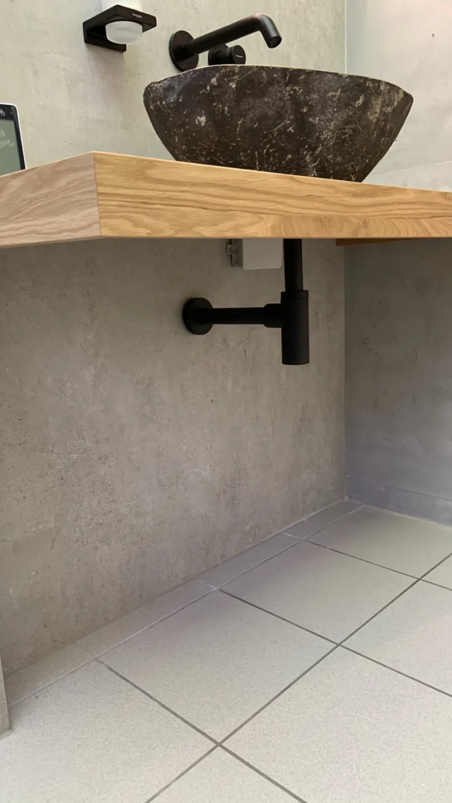 Ein Waschtisch in einem Gästebad in Holz-Optikholz