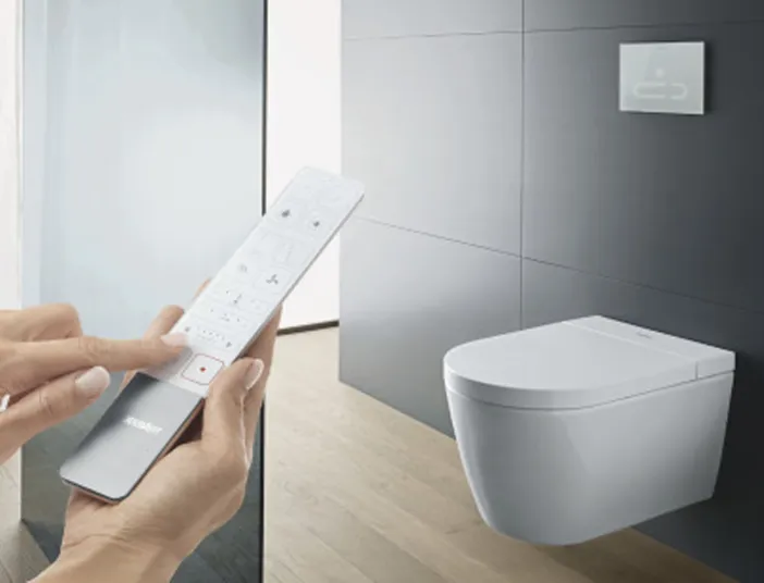 Duravit WC an der Wand mit Fernbedienung in einer Hand