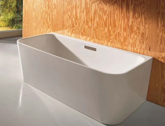 Badewanne I BetteArt vor einer Holzwand.